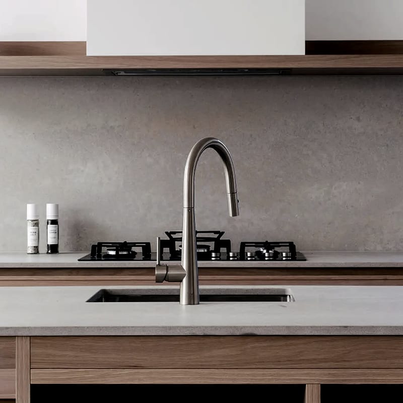 Kitchen detail with a stone splashback, timber shelf, gas cooktop and brushed steel tap